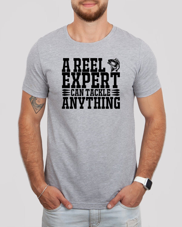 A reel expert can tackle anything black lettering med gray t-shirt